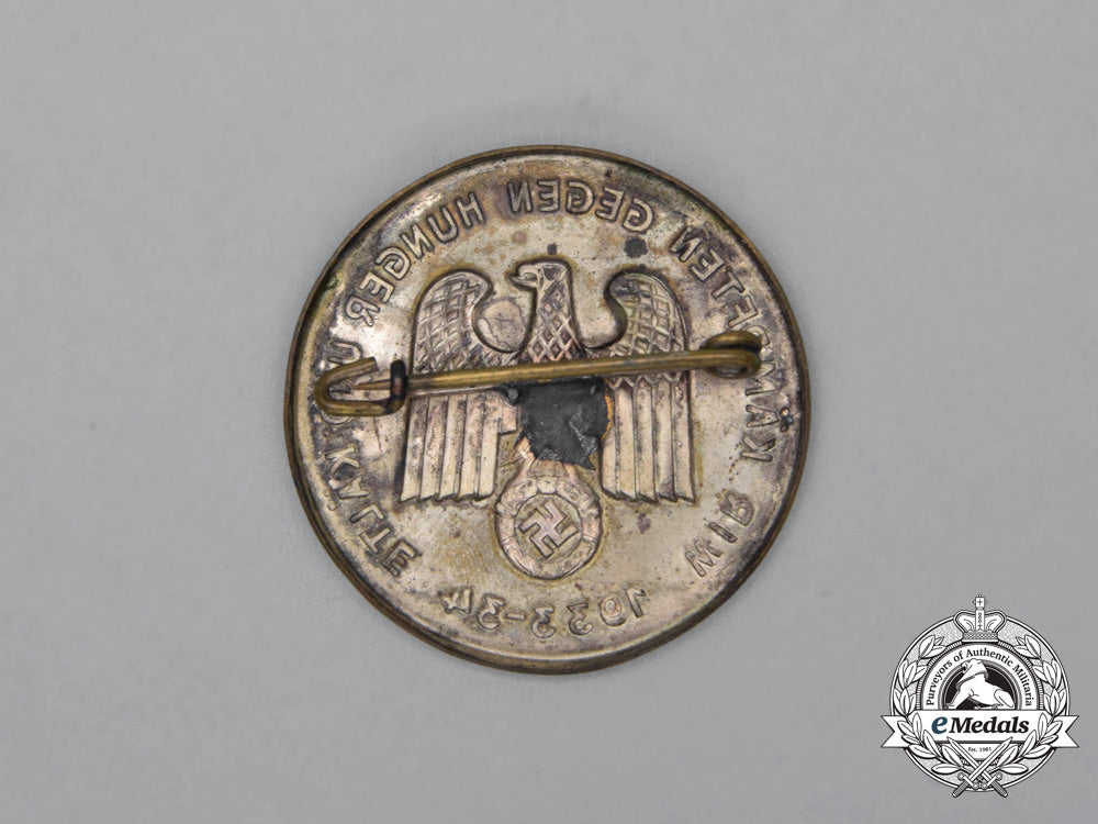 a1933/34_whw“_we_are_fighting_against_hunger_and_the_cold”_badge_h_617_1