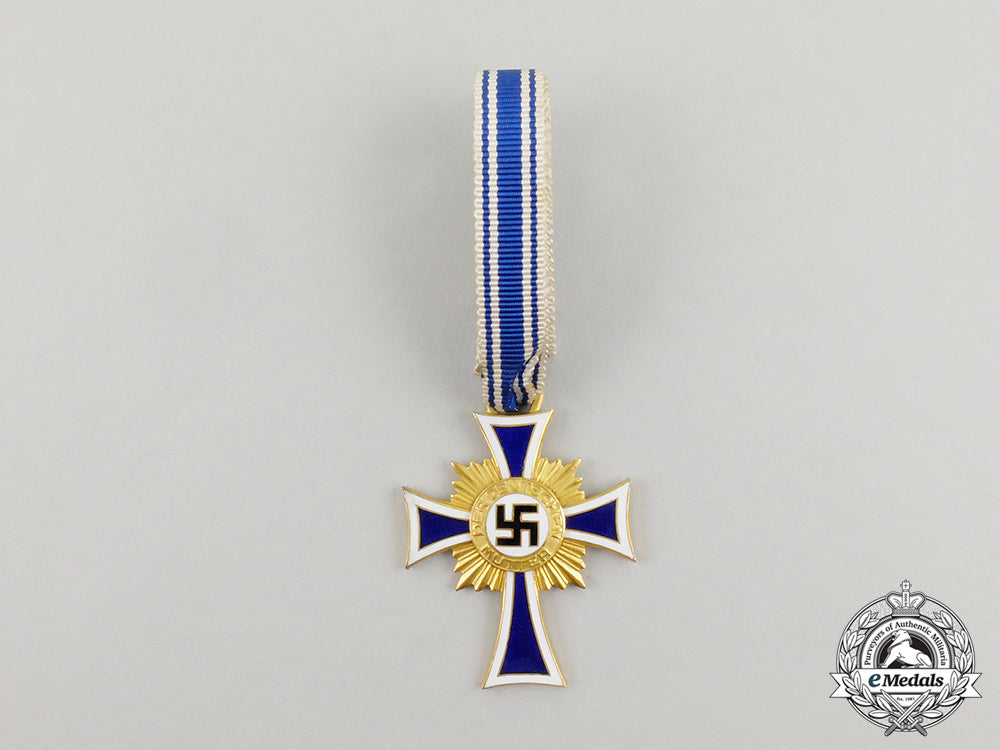 a_cased_gold_grade_mother’s_cross_with_instructions_for_wear_m17-000071