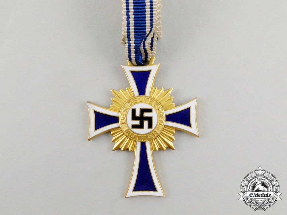 a_cased_gold_grade_mother’s_cross_with_instructions_for_wear_m17-000072