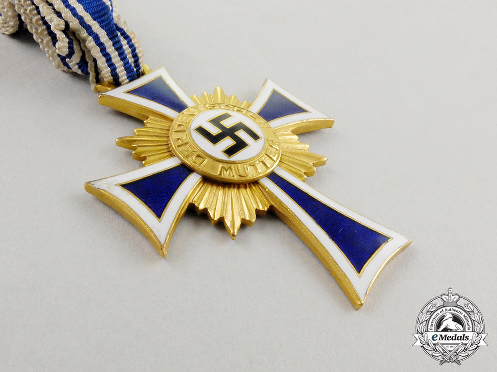 a_cased_gold_grade_mother’s_cross_with_instructions_for_wear_m17-000075